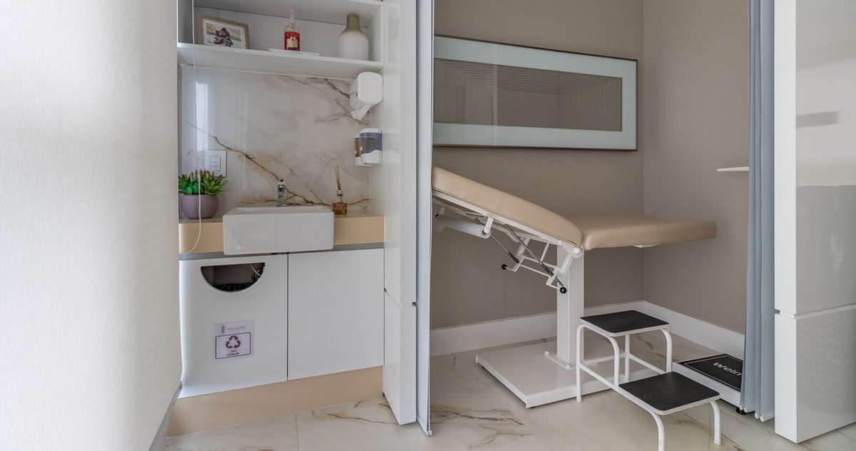 Sala de exames com maca e bancada de higienização