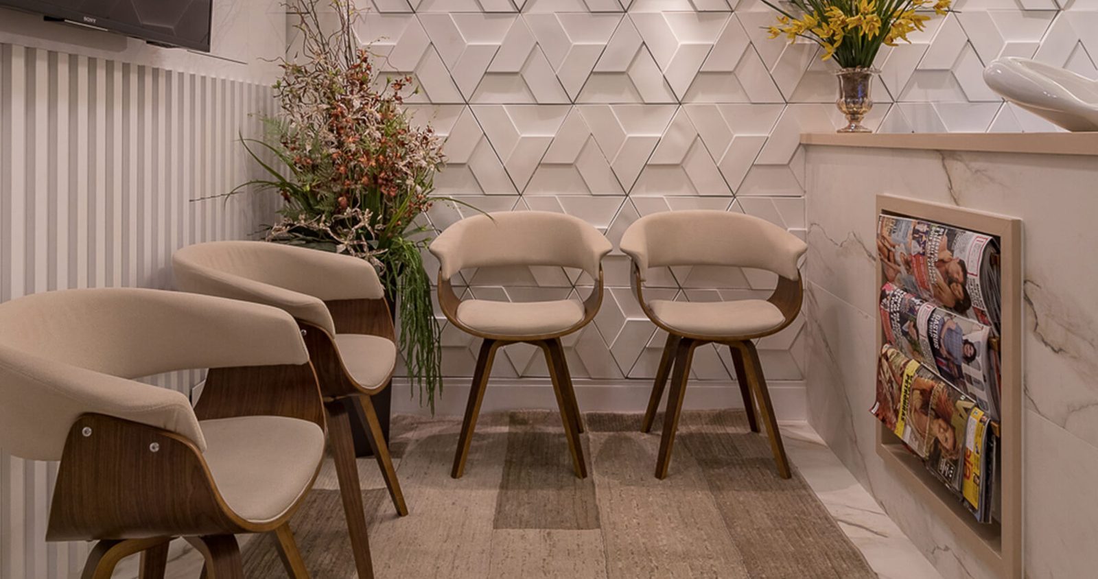 Sala de espera com cadeiras de madeira estofadas e parede 3D