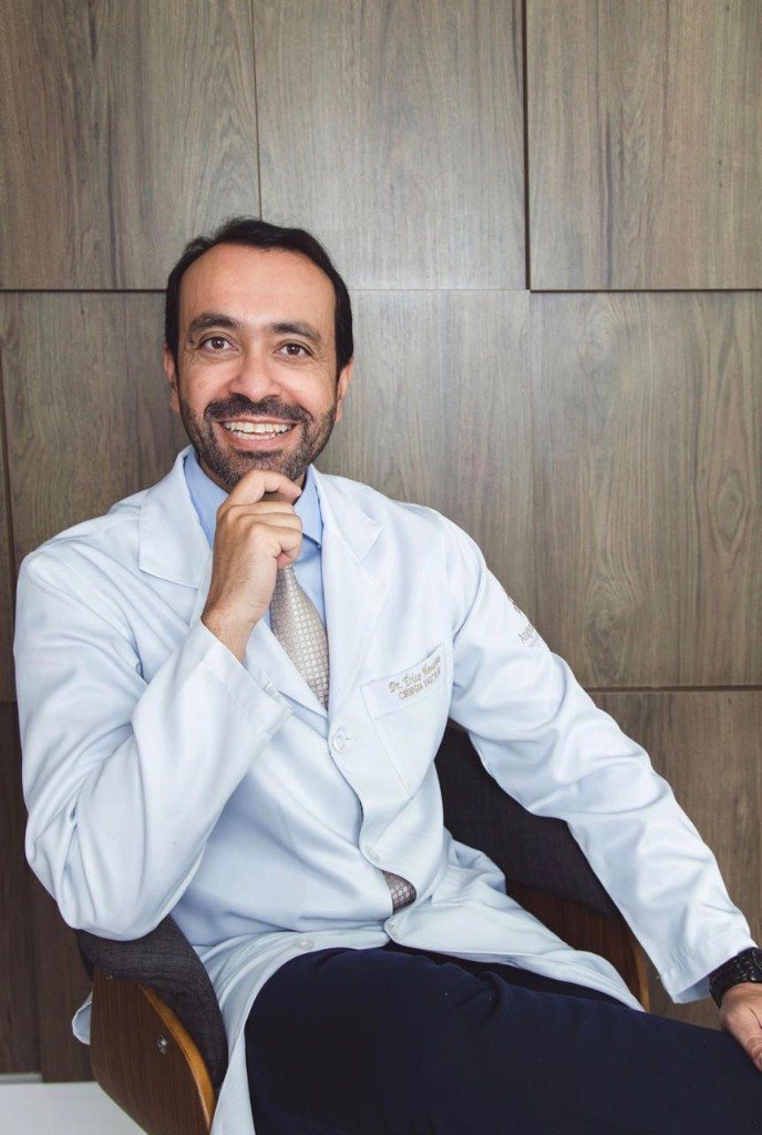 Dr. Érico Honorato, cirurgião vascular, de jaleco no consultório